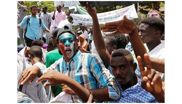 Protesters make victory signs and shout slogans in front of the Defence Ministry in Khartoum, yesterday.