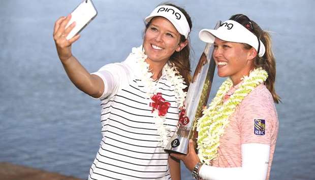 Brooke Henderson (right) celebrates with the trophy after winning the Lotte Championship with her sister and caddie Brittney Henderson in Kapolei, Hawaii, on Saturday. (AFP)