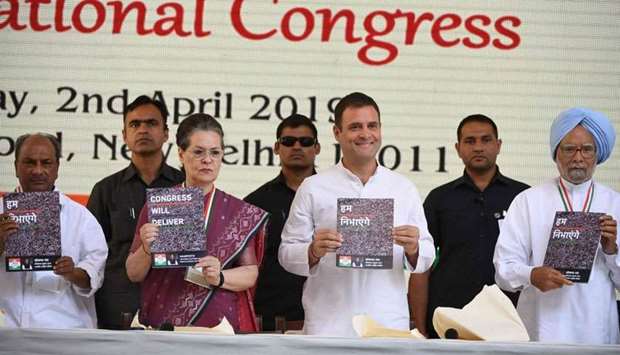 Indian National Congress party president Rahul Gandhi (centre R) and the party's former president Sonia Gandhi (centre L) pose with copies of their party election manifesto in New Delhi