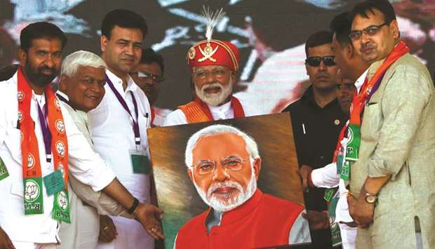 Prime Minister Narendra Modi holds a canvas displaying a portrait of himself during an election rally in Chittorgarh in Rajasthan, yesterday.