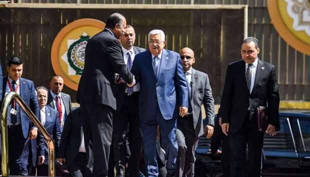 Palestinian president Mahmoud Abbas (C) is greeted upon his arrival at the Arab League headquarters in the Egyptian capital Cairo, to discuss the latest developments in the Palestinian territories