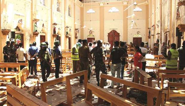 Security personnel walk through debris following an explosion in St Sebastianu2019s Church in Negombo, north of the capital Colombo yesterday.