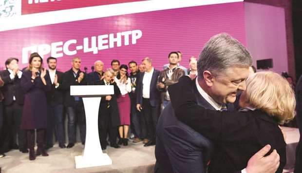 Poroshenko receives a hug at his campaign headquarters in Kyiv, at the end of a day of polling in the second round of national elections in which he lost.
