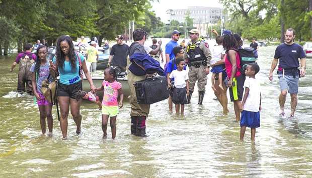 An August 31, 2017, file photo of families being evacuated in Houston.rnrn