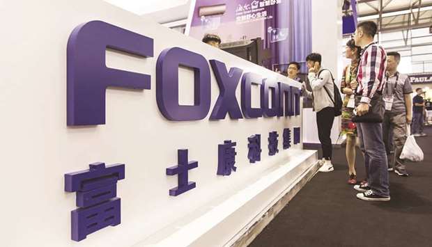 A signage for Foxconn Technology Group is displayed at the companyu2019s booth at the CES Asia 2018 show in Shanghai. The company is within weeks of starting trial production of the latest iPhones in India as Apple Inc seeks to revive its fortunes in the country, people familiar with the matter said.