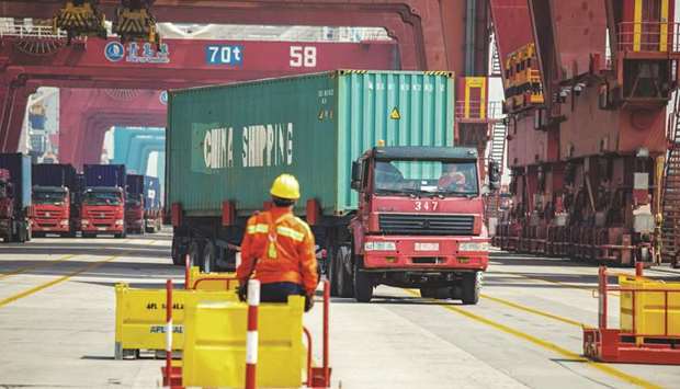 A staff member watches a truck carrying a container at a port in Qingdao in Chinau2019s eastern Shandong province. China may be poised to take more stimulus steps to drive an expansion showing renewed signs of health.