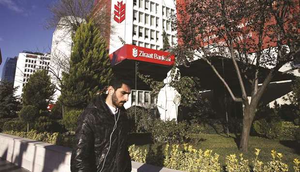 A commuter walks outside Ziraat Bankasi headquarters in the business district of Maslak in Istanbul (file). Around 38% of the total issuance, u20ac1.4bn, will be used to boost Ziraat, Turkeyu2019s largest bank by asset size, the treasury said.