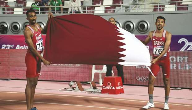Qataru2019s Abubaker Haydar Abdalla (L) celebrates winning the menu2019s 800m final with third placed Jamal Hairane.