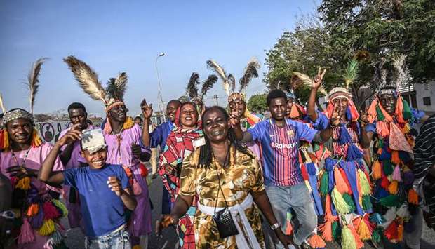 Sudanese protesters wearing traditional clothes dance during a protest outside the army headquarters in Khartoum, yesterday.