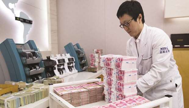 An employee arranges yuan banknotes at the Korea Exchange Bank headquarters in Seoul. The yuan eased to a 10-day low against the dollar yesterday, but the Chinese economyu2019s solid first quarter performance has tempered expectations that Beijing will step up more stimulative policies.