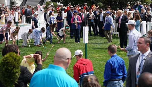 President Donald Trump and First Lady Melania Trump blow whistles to start a race during the annual White House Easter Egg Roll on the South Lawn of the White House in Washington yesterday.