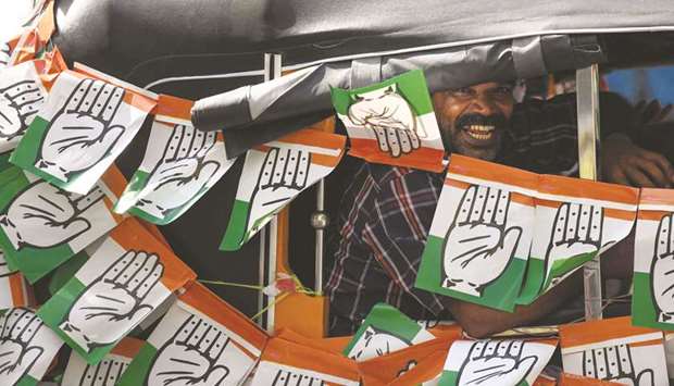 In this photo taken on April 21, a supporter of the Congress gestures in an auto-rickshaw decorated with party flags during the final day of election campaigning in Pathanamthitta in Kerala.