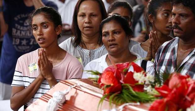 People attend a mass burial of victims, two days after a string of suicide bomb attacks on churches and luxury hotels across the island on Easter Sunday, at a cemetery near St. Sebastian Church in Negombo, Sri Lanka