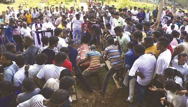 Relatives pour soil on the coffin of a bomb blast victim during a funeral in a cemetery in Colombo yesterday, two days after a series of bomb attacks targeting churches and luxury hotels in Sri Lanka.