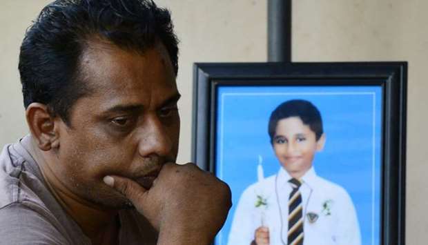 Ranjeewa Silva 46, father of St Sebastian's Church suicide blast victim Enosh Silva, 12, cries next to Enosh's portrait at his house, in Negombo