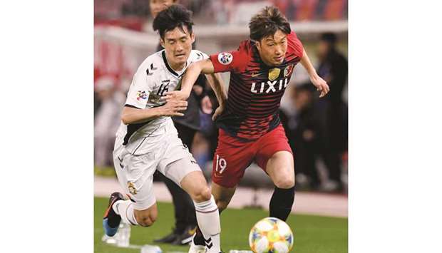 Gyeongnamu2019s Lee Kwang-Jin (left) fights for the ball with Kashimau2019s Kazuma Yamaguchi during the AFC Champions League Group E match in Kashima, Japan, yesterday. (AFP)