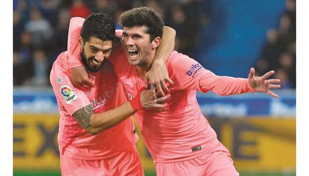 Barcelonau2019s Carles Alena (right) celebrates with teammate Luis Suarez after scoring a goal against Deportivo Alaves during the La Liga match at the Mendizorroza stadium in Vitoria, Spain, on Tuesday night. (AFP)