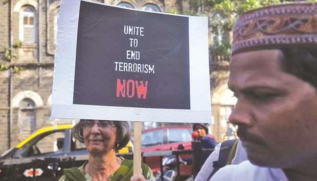 A woman holds a placard during a solidarity gathering for the victims of Sri Lankau2019s serial bomb blasts, in Mumbai yesterday.