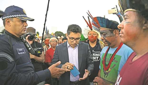 Police talk to indigenous people protesting outside the National Congress building in Brasilia, Brazil, yesterday.