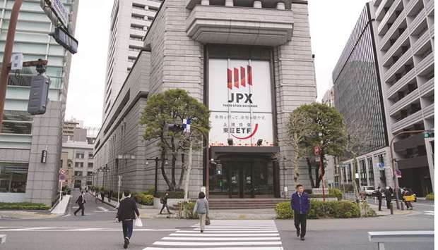 Pedestrians walk by the Tokyo Stock Exchange building. Tokyo stocks edged up 0.5% yesterday.