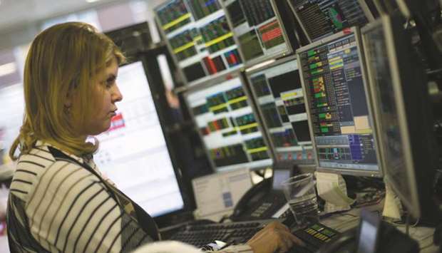 A trader studies information on trading screens at ETX Capital in central London (file). The FTSE 100 fell 0.5% to close at 7,434.13 points yesterday.
