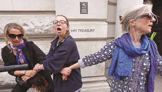 Climate protesters are seen with their hands glued together in front of HM Treasury in Westminster during the Extinction Rebellion protest in London yesterday.