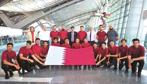 Qatar Under-19 team players and officials pose with Qatar flag.