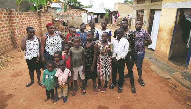 Mariam Nabatanzi, 39, (red hair) takes a family portrait with some of her children at their home in Kasawo village, east of Kampala.