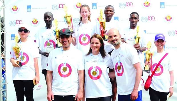 Front row: Mohamed Hassan al-Obaidly, Dr Bahia Tahzib-Lie and Houtan Homayounpour with the top finishers at the first Qatar Workers' Fun Run awards ceremony. Pius Nyaundi (third right, back row) was the fastest runner. PICTURES: Ram Chand.