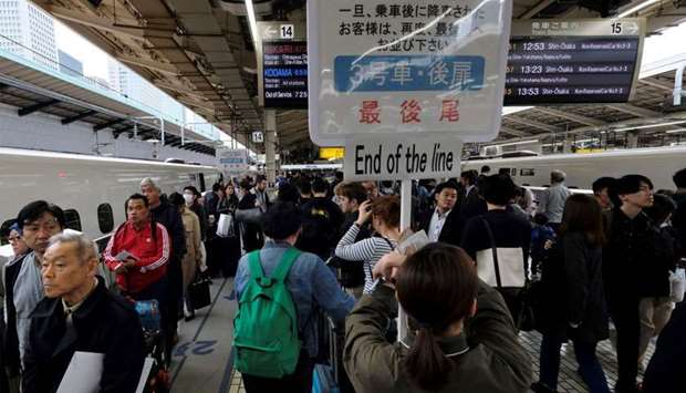 Passengers wait for a train at Tokyo railway station, beginning of the unprecedented 10-day Golden Week holiday