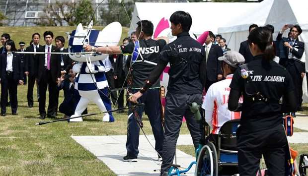 Archers shoot at targets as part of the opening ceremony of the Yumenoshima Park Archery Field, a new permanent venue that will be used for the Olympic Games and Paralympic Games in 2020