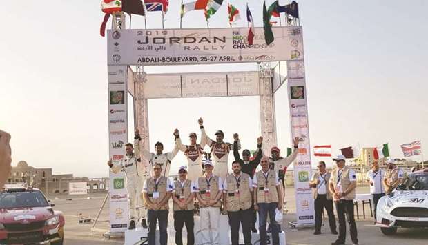 Qataru2019s Nasser Saleh al-Attiyah and his French co-driver Matthieu Baumel celebrate on the podium after winning the Jordan Rally yesterday. At bottom, Qataru2019s Abdulaziz al-Kuwari powers through the desert on way to his second place finish.