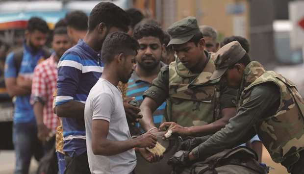 Sri Lankan army personnel search people and their bags at a check point in Kattankudy near Batticaloa, yesterday.