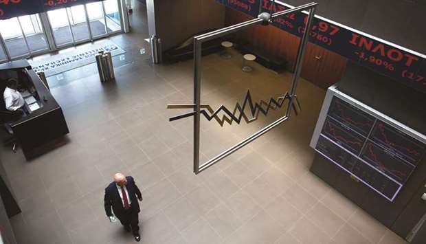 A visitor passes beneath a display of stock market price information at the entrance to the Athens Stock Exchange in Greece (file). A world-beating rally this year may be more than just a rebound for Greek stocks, with investors betting an improving economic backdrop will drive further gains.