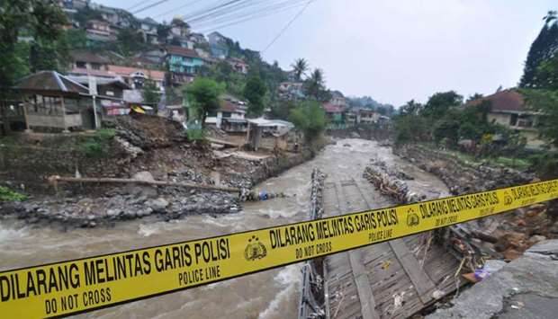 A police line is placed at a damaged bridge following torrential rain in Bogor, West Java