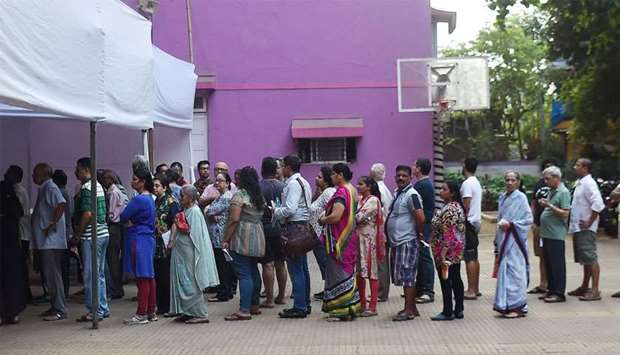 Indian voters wait for start of voting at a polling booth in Mumbai