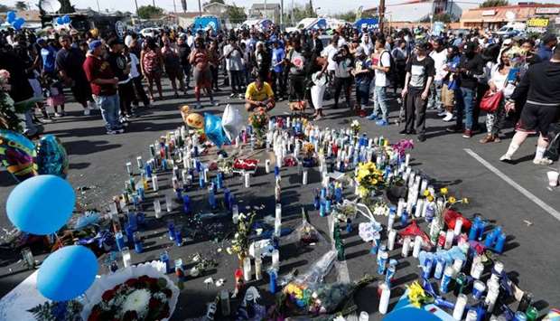 People gather around a makeshift memorial for Grammy-nominated rapper Nipsey Hussle who was shot and killed outside his clothing store in Los Angeles