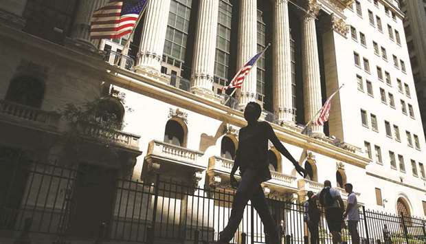 People walk by the New York Stock Exchange. In a win for Wall Street banks, the latest effort to overhaul the post-crisis Volcker Rule is moving towards a narrower and clearer definition of what types of trades are prohibited, said people familiar with the matter.