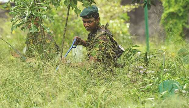 A Sri Lankan Special Task Force (STF) soldier checks a burial ground in Colombo yesterday, a week after a series of bomb blasts targeting churches and luxury hotels on Easter Sunday in Sri Lanka.