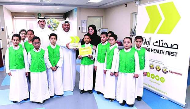 Officials from the Ministry of Education and Higher Education with the principal and some of the students of Jawaan Bin Jassim Primary School for Boys.