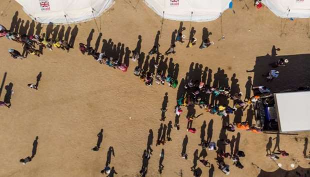 An aerial view taken in Beira, Mozambique, on April 1, shows displaced people queuing for supplies at the Picoco refugee camp
