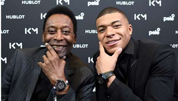 Brazilian football legend Pele (L) poses with Paris Saint-Germain and France national football team forward Kylian Mbappe during their meeting at the Hotel Lutetia in Paris on April 2, 2019