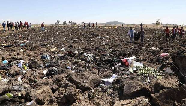 Rescue teams collect bodies in bags amid debris at the crash site of Ethiopia Airlines near Bishoftu
