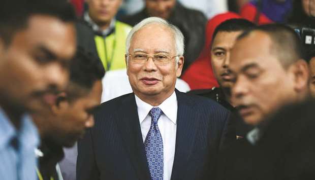 Malaysiau2019s former PM Najib Razak (centre) leaves a court in Kuala Lumpur yesterday.