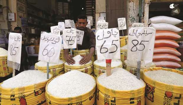 A vendor arranges different types of rice, with their prices displayed, at his shop in a wholesale market in Karachi. Pakistanu2019s economy is experiencing severe balance of payment difficulties amid large fiscal and current account deficits and mounting pressures on the currency, a report said.