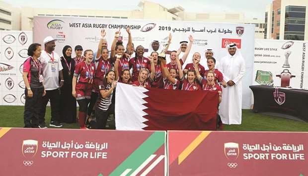 Qatar A womenu2019s rugby team celebrates their victory in the Asia Rugby West Rugby Sevens with the winnersu2019 trophy, Qatar Rugby Federation president Yousef Jeham al-Kuwari, secretary-general Abdullah al-Khater, and other officials at Aspire Warm Up Track yesterday. PICTURE: Othman Khalid