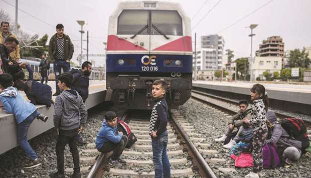 Migrant children stand on the rails to block the line during a protest at Larissis railway central station in Athens.