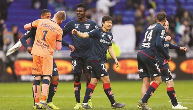 Dijon players celebrate after winning their Ligue 1 match against Olympique Lyonnais in Lyon, France, yesterday. (Reuters)