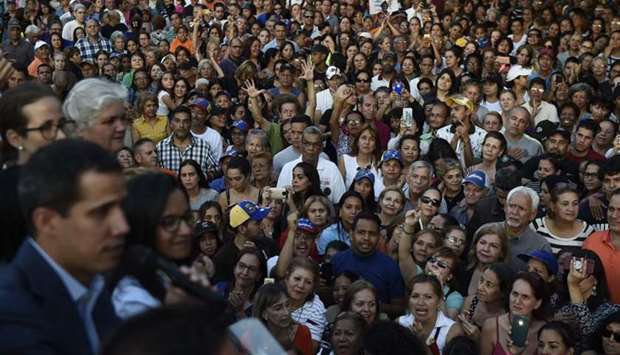 Supporters of Venezuelan opposition leader and self-proclaimed interim president Juan Guaido listen to him (L) speaking during a rally at El Paraiso neighbourhood in Caracas yesterday.