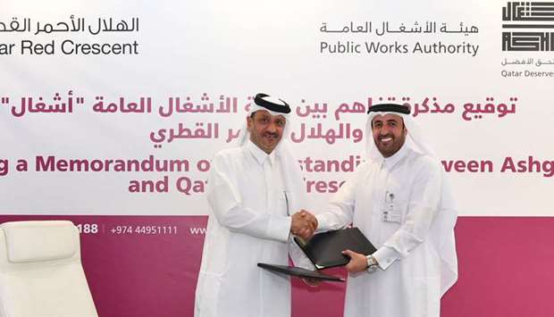 Meshal Sultan al-Hitmi, Ashghalu2019s Shared Services Affairs Director, and Ibrahim Abdullah al-Maliki, Chief Executive Director at Qatar Red Crescent Society,  shake hands after signing the MoU.